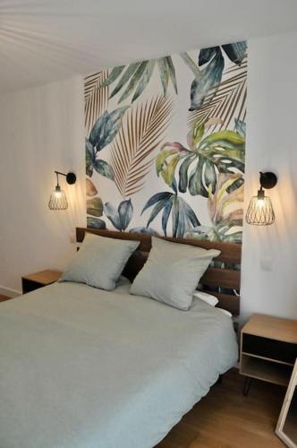 - une chambre avec un lit blanc et une fresque murale dans l'établissement Elégant & spacieux, place du Dauphin à Pornichet, à Pornichet