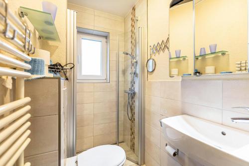 ein Bad mit einem WC und einem Waschbecken in der Unterkunft Heidi in Tönning