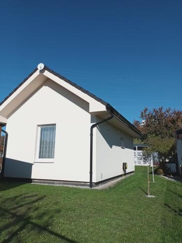 a white house with a dog in the yard at Domček v záhrade in Liptovský Mikuláš