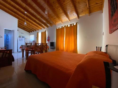 Un dormitorio con una gran cama naranja y una mesa. en Complejo Anita Departamento Studio 08, en Las Grutas