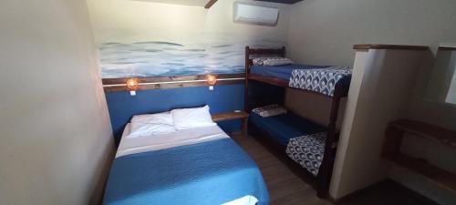 a small room with two bunk beds in a ship at Maré Alta - Apartamentos Studio in Ilha do Mel