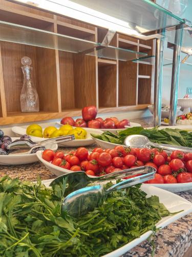 a counter with plates of tomatoes and other fruits and vegetables at Güllük Yalı Boutique Otel in Gulluk