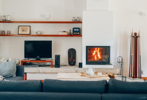 a living room with a couch and a fireplace at Just Like Home - Casa do Sobreiro Velho em Cerveira in Vila Nova de Cerveira