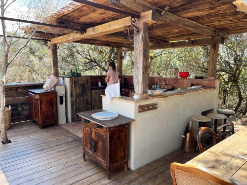 une femme debout dans une cuisine sur une terrasse dans l'établissement Domaine de la coletta Maison traditionnelle, à Coti-Chiavari
