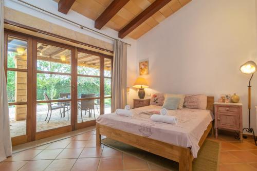 a bedroom with a large bed and a patio at Ses Tendes in Algaida