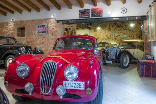a red car parked in a garage with other cars at Ses Tendes in Algaida
