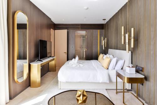 um quarto com uma cama branca e uma televisão em Five Palm Residences em Dubai