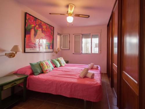 a bedroom with a pink bed with a pink blanket at Holiday Home Mijas-Costa near Beach in La Cala de Mijas