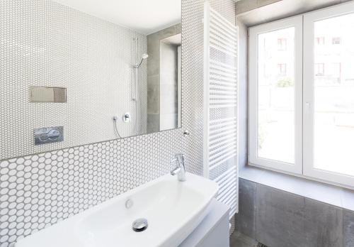 a white bathroom with a sink and a window at TurnKey I Studio by Amazing Park in Prague