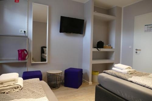 a room with two beds and a tv on the wall at Pension Sölde UG in Dortmund