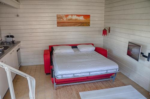 um pequeno quarto com uma cama no canto em Artistiek Vakantiehuisje em Hulst