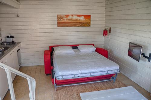 een kleine kamer met een bed in de hoek bij Artistiek Vakantiehuisje in Hulst