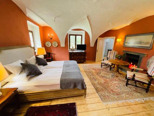 Schloss Moosburg Gästehaus في موسبرغ: غرفة نوم بسرير كبير ومدفأة