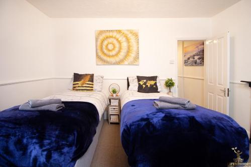 a bedroom with two beds with blue sheets at Modern Quirky Exeter City Cottage 2 min walk - shops in Exeter