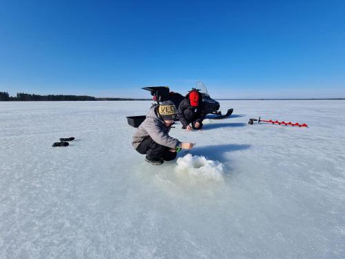 a child playing in the snow on a frozen lake at Rantarovio in Alvajärvi