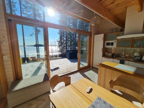uma cozinha com uma mesa e uma grande janela de vidro em Rantarovio em Alvajärvi