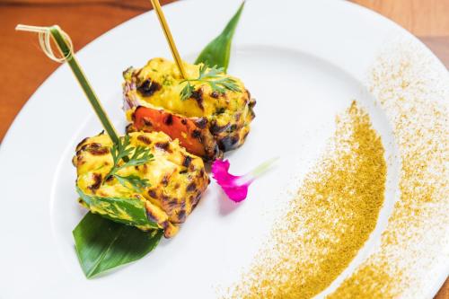a white plate topped with food on a table at Denissons Beach Resort, formerly Gamyam Retreat in Kumta