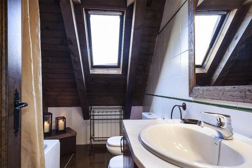 a bathroom with a sink and a toilet and a mirror at Luderna - Casa Sendrosa in Gessa