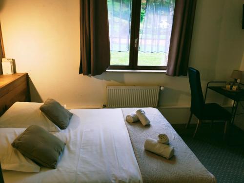 a bedroom with a bed with two towels on it at Hôtel Restaurant l’Éolienne in Rouxmesnil-Bouteilles