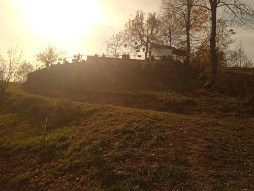 a hill with the sun shining on the top of it at Stablo guest house in Bărăşti