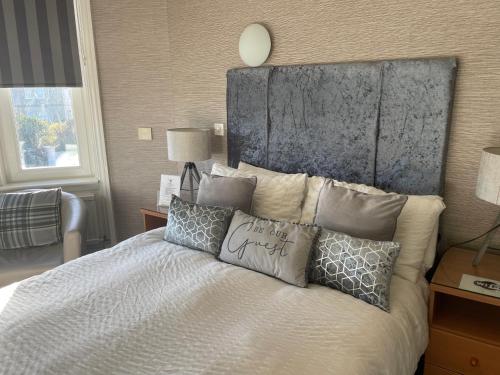 a bedroom with a bed with pillows on it at Beechwood Ensuite Guest House in Ayr