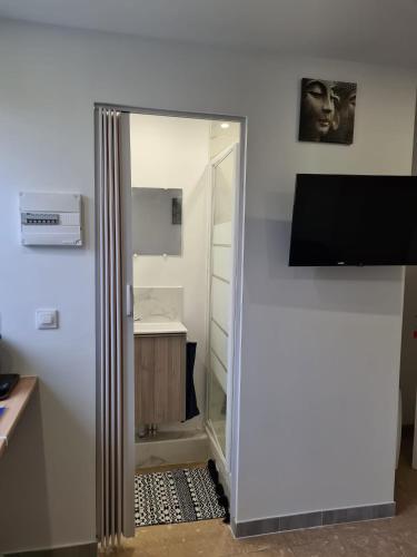 - un miroir dans une chambre à côté d'un bureau dans l'établissement Studio bien équipé et indépendant avec véranda commune, à Neuilly-sur-Marne