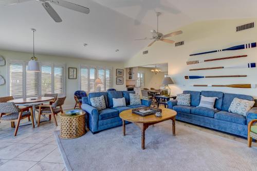 a living room with blue couches and a table at Fletcher Family Friendly Home in Fernandina Beach