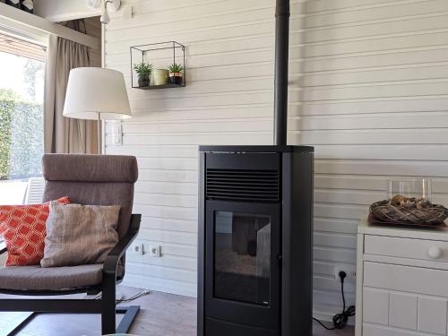 a living room with a fireplace and a chair at Seaside in Middelkerke