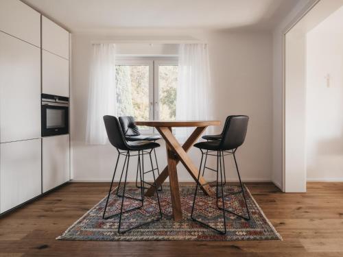a kitchen with a wooden table and three chairs at Das Dietrich - Landhaus 58 in Leibnitz