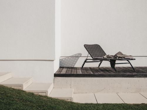 a chair sitting on a porch next to a building at Das Dietrich - Landhaus 58 in Leibnitz