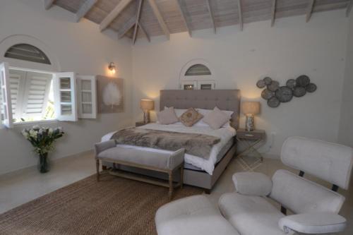 1 dormitorio con 1 cama, 2 sillas y sofá en Luxury 4 bed villa in Mullins St Peter - Sugar Palm House, en Saint Peter