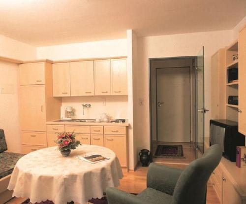 a kitchen with a table with a vase of flowers on it at Appartement Haus Salzburg in Bad Füssing