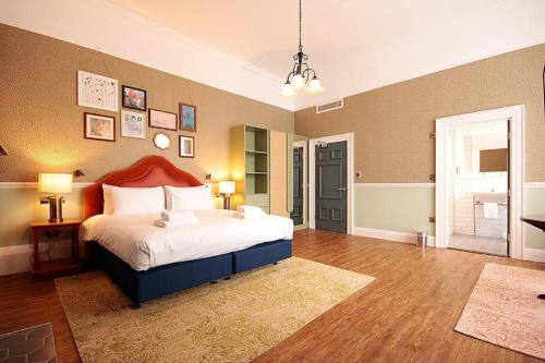 sypialnia z dużym łóżkiem z czerwonym zagłówkiem w obiekcie Elmbank Hotel - Part of The Cairn Collection w mieście York