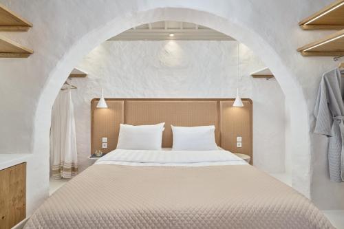GrandeMar Suites في مدينة أستيباليا: غرفة نوم مع سرير كبير مع ممر