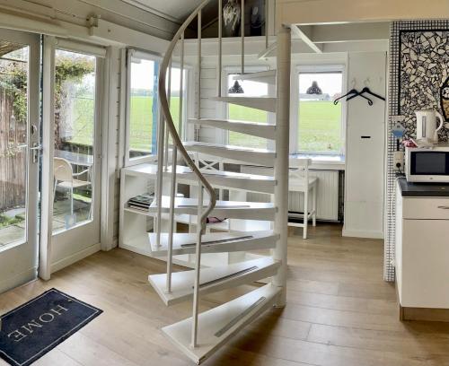 a spiral staircase in a tiny house with a kitchen at Artistiek Vakantiehuisje in Hulst