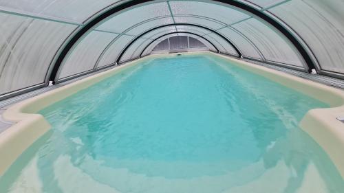 an indoor swimming pool with blue water in a tunnel at AMW Ferienwohnungen in Legau