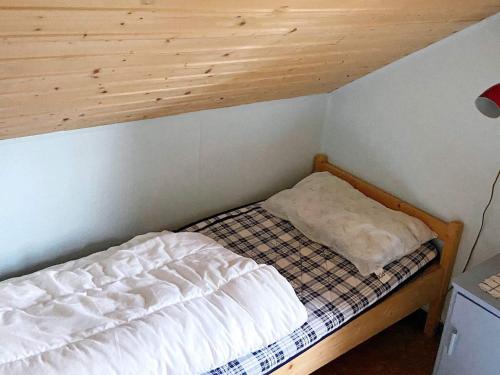 Hardbakke的住宿－Holiday home HARDBAKKE II，一张小床,位于一个拥有木制天花板的房间