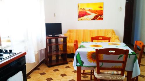 a kitchen with a table with a sunfloweridered table and chairs at Favignana Vacanze in Favignana