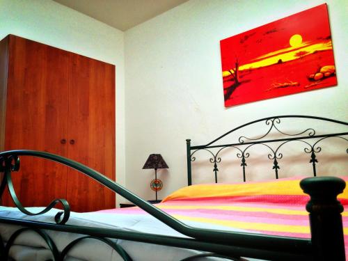 a bedroom with a bed and a painting on the wall at Favignana Vacanze in Favignana