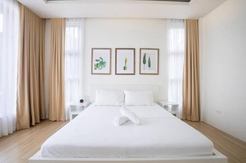 a white bedroom with a large white bed at Addie's Place Camella Homes 2D Muntinlupa in Manila