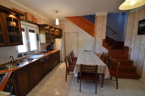 a kitchen with a table and chairs and a staircase at Nora Ház Hajdúszoboszló in Hajdúszoboszló