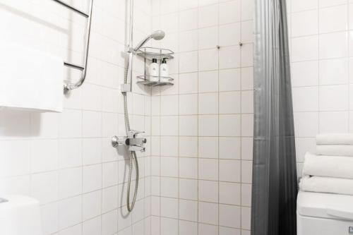 a shower with a shower head in a bathroom at 1br apartment with patio in Lauttasaari in Helsinki