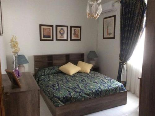 1 dormitorio con cama, mesa y cuadros en la pared en Seafront Penthouse with Terrace in Xlendi, Gozo, en Xlendi