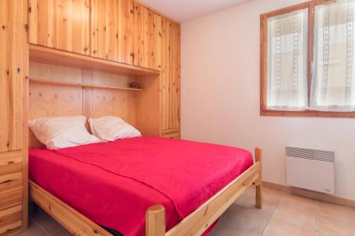 a bedroom with a bed with a red blanket at Trilocale fronte piste a Montgènevre in Montgenèvre