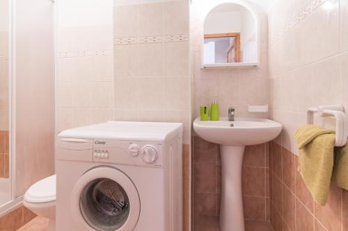 une salle de bain avec une machine à laver et un lavabo dans l'établissement Trilocale fronte piste a Montgènevre, à Montgenèvre