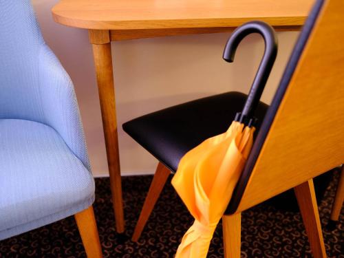 a yellow umbrella sitting on a chair next to a table at Logis Hôtel de l'Europe in Poitiers