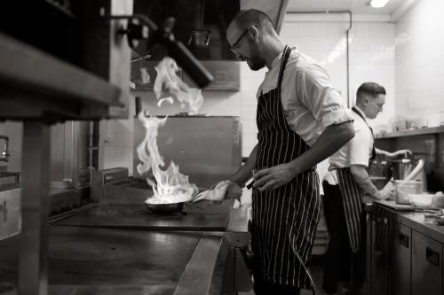two men in a kitchen preparing food in a kitchen at Macdonald Houstoun House in Livingston
