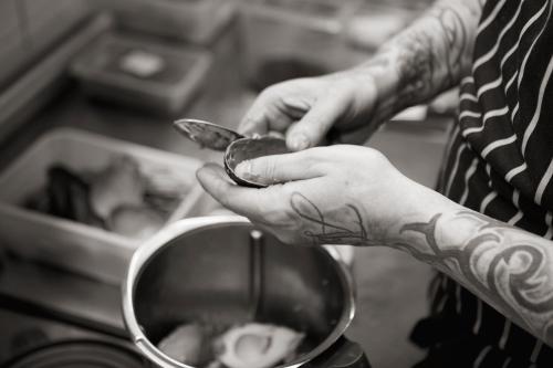 a person with a tattooed hand holding a spoon at Macdonald Houstoun House in Livingston