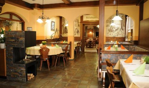 une salle à manger avec des tables et des chaises dans un restaurant dans l'établissement Gasthof Mühle – Natur- & Wanderhotel, à Rinchnach