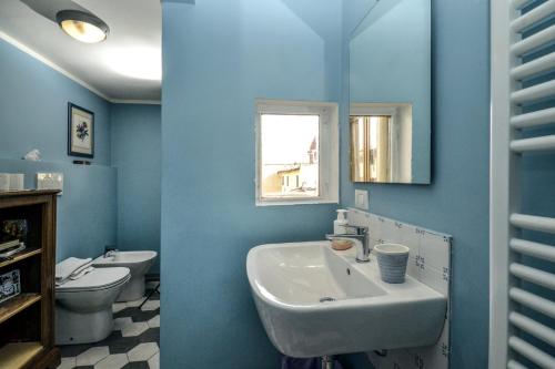 bagno blu con lavandino e servizi igienici di Palazzo Panzani a Firenze